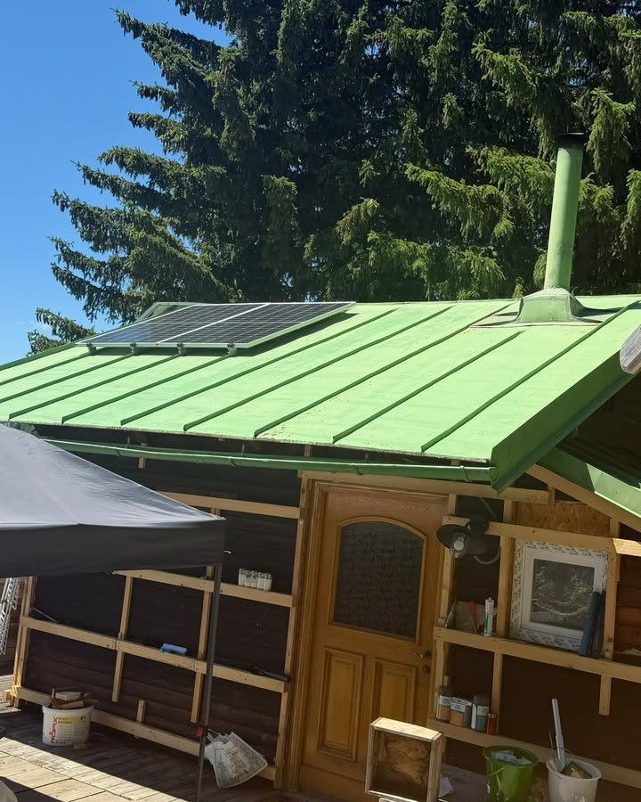 Hütte mit grünem Blechdach und Photovoltaik-Modul am Zettersfeld – Anlage von ELMETIC