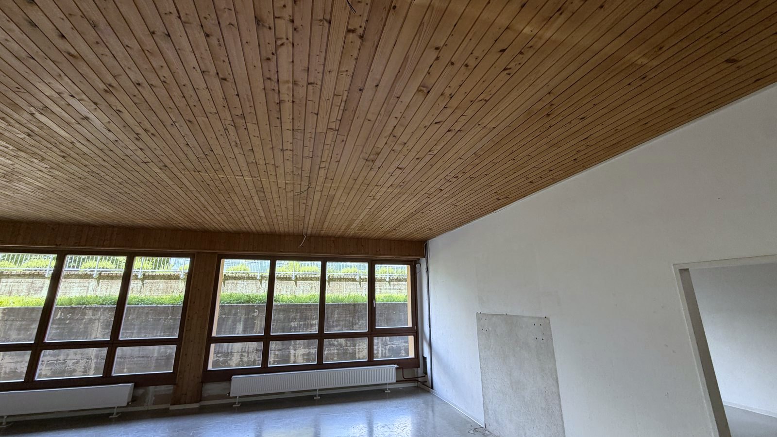 Aufenthaltsraum vor dem Umbau: alte Holzdecke ohne moderne Beleuchtung